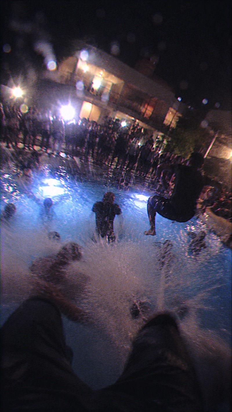 POV: saut depuis le balcon dans la piscine la nuit, grosse gerbe d'eau